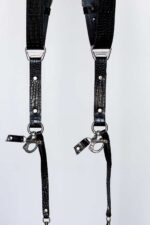 Front-facing symmetrical view of both strap ends of the Black Croc harness, showing the glossy crocodile-embossed leather, "GENUINESTRAP" branded triangular D-ring connectors, silver rivets, O-rings, and marine-grade snap hooks with croc leather safety tabs.