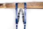 Front view of Blue Shanty harness showing dual royal blue leather shoulder straps with white stitching detail, grey center X-strap with navy blue adjustable leather bands, and metal hardware