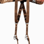 Full-length front view of the Brown Vintage leather dual camera harness hanging from a rustic wooden branch, showing the complete harness with distressed tan leather straps, dark brown crossback, D-ring shoulder attachments, antique-finish buckles, branded triangular connectors, and snap-hook camera attachments with leather safety tabs at the bottom.