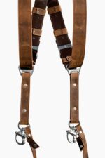 Front-facing view of both strap ends of the Brown Vintage harness, showing the distressed tan leather with natural wear marks, dark brown leather crossback and keeper loops, antique-finish buckles, branded triangular D-ring connectors, silver rivets, and marine-grade snap hooks with brown leather safety tabs.