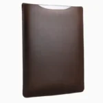 Dark brown leather MacBook sleeve displayed at angle, showing rich leather color, stitched seams, and curved protective shape