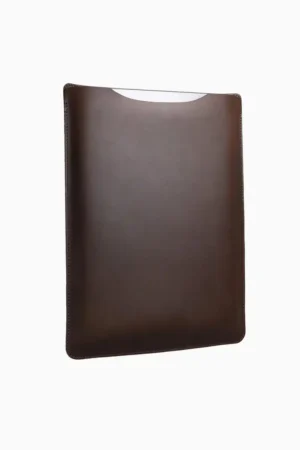 Dark brown leather MacBook sleeve displayed at angle, showing rich leather color, stitched seams, and curved protective shape