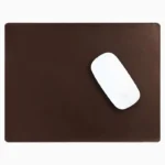 Dark brown leather mouse pad with tone-on-tone perimeter stitching and rounded corners, with a white wireless mouse placed on the right side, top-down view on a white background.