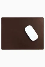 Dark brown leather mouse pad with tone-on-tone perimeter stitching and rounded corners, with a white wireless mouse placed on the right side, top-down view on a white background.