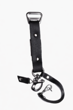 Close-up of black leather camera strap end with silver clasp and rivet details on a light background.