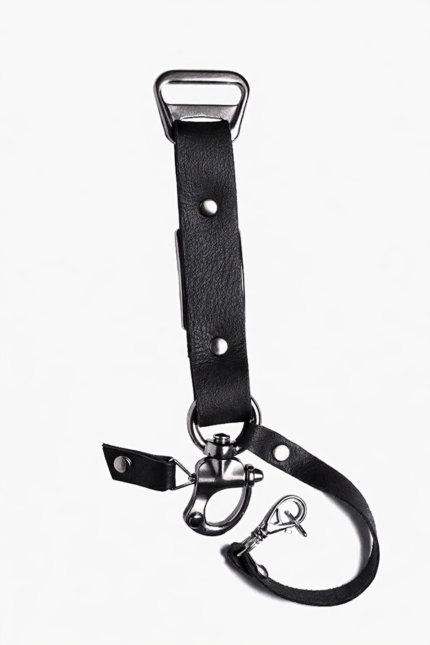 Close-up of black leather camera strap end with silver clasp and rivet details on a light background.