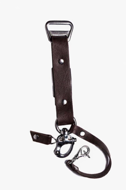 Close-up of dark brown leather camera strap end with silver clasp and rivet details on a light background.