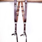 Dark brown leather dual camera harness straps shown full length on a white background.