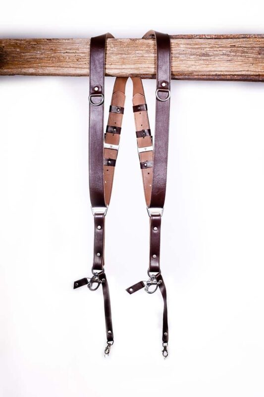 Dark brown leather dual camera harness straps shown full length on a white background.