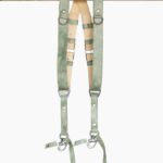 Full-length front view of the Green Marble leather dual camera harness hanging from the "Genuine Strap" branded wooden beam, showing the complete harness with cream leather crossback, marbled sage-green straps, silver buckles, D-rings, triangular connectors, and snap-hook camera attachments with green leather safety tabs at the bottom.
