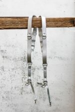 Complete front display of Grey Flower Embossed camera harness showing X-design with silver shoulder straps featuring embossed floral motif, light grey center strap with darker grey accent bands, metal D-ring attachments, and carabiner clips