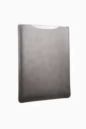 Grey leather MacBook sleeve photographed at angle, showing smooth leather surface, contoured shape, and hand-opening top edge