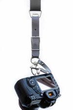 Centre strap detail of Grey Sandstone harness showing layered leather segments with metal square connectors, rivets, and stitching