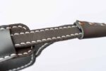 Grey leather strap close-up highlighting white stitching and edge finishing