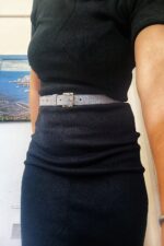 Cintura pantalone imbottita grigia glitter indossata su abito nero, fibbia argentata