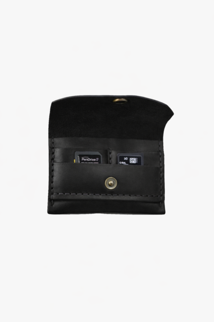 Black leather battery and SD card holder opened to show storage slots with memory cards inside on a light gray background.