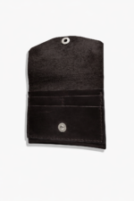 Open dark brown leather battery and SD card holder with multiple card slots, snap closure, and suede interior on a light gray background.