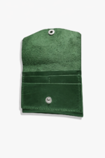 Open green leather battery and SD card holder with multiple card slots, snap closure, and suede interior on a light gray background.