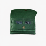 Green leather battery and SD card holder opened to show storage slots with memory cards inside on a light gray background.