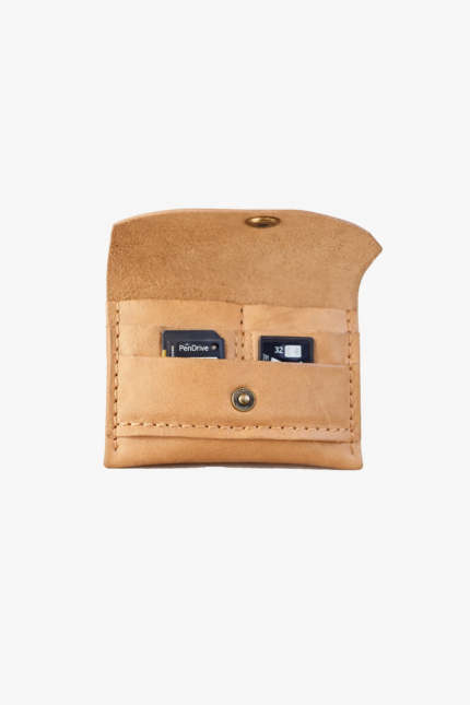 Light brown leather battery and SD card holder opened to show storage slots with memory cards inside on a light gray background.