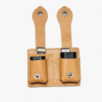 Light brown leather dual battery holder with two hanging tabs on a light background.
