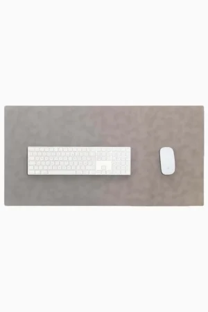 Top-down view of a light gray leather desk mat with stitched edges on a white background, with a white full-size wireless keyboard centered on the left and a white wireless mouse on the right.