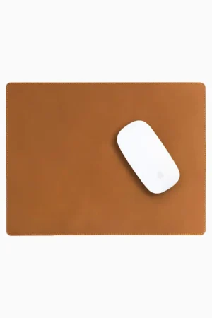 Light brown tan leather mouse pad with tone-on-tone perimeter stitching and rounded corners, with a white wireless mouse placed on the right side, top-down view on a white background.