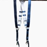 Royal Blue Metallic leather camera harness displayed flat on weathered wood showing full X-design with bright blue shoulder straps and white center strap with black and blue leather accent patches