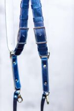 Close-up of dual Royal Blue Metallic leather camera straps showing rectangular metal connectors with white stitching detail and rivet hardware