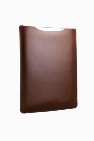 Vintage brown leather MacBook sleeve with patina finish, displayed at angle showing aged leather surface and protective curved shape