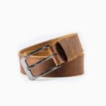 Tan leather belt with silver buckle on white background