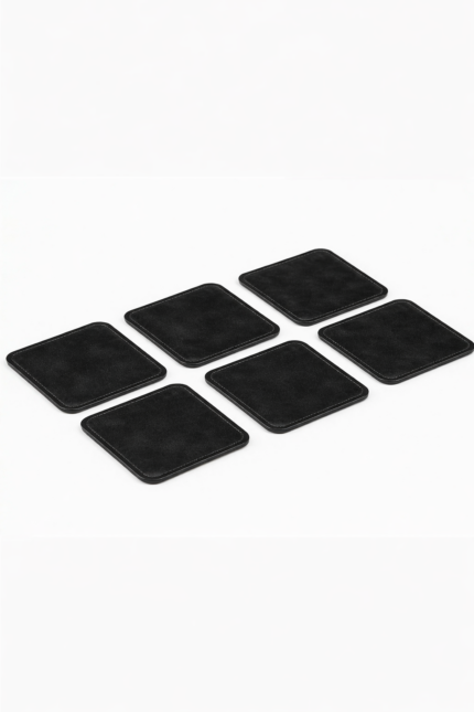 Set of six black leather coasters with stitched edges arranged on a light gray background.