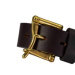 Black leather belt with large gold buckle close-up