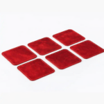 Set of six red leather coasters with stitched edges arranged on a light gray background.