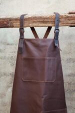 Leather apron with chest pocket worn by barber – side view showing adjustable strap