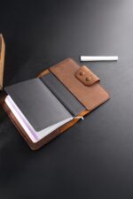 Black leather journal notebook open showing lined pages