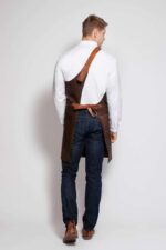 One strap leather apron worn by man – side view showing adjustable strap