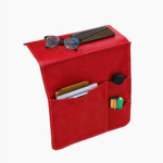 Red leather wall pocket organizer holding glasses, mail, and small accessories on a light background.