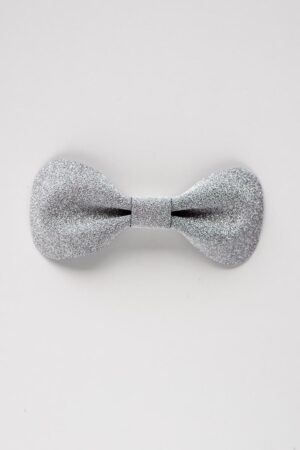 Close-up of a single silver glitter leather bow tie on a clean white background, showing the textured sparkle finish and sculpted butterfly shape.