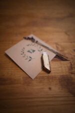 Wooden USB drive placed on a printed card with dried lavender on a wooden table