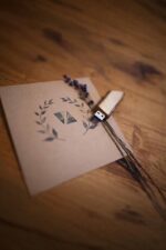 Wooden USB stick standing on a card with floral print on a wooden table