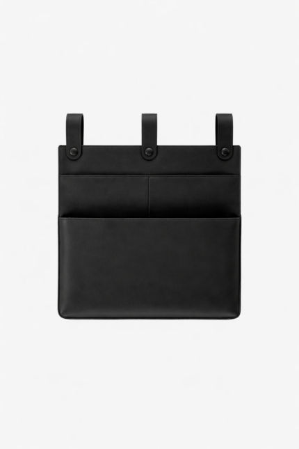 Black leather wall pocket organizer with three hanging tabs on a light background.