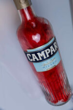 Handcrafted Campari bottle lamp – on wooden surface