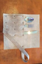 leather cutlery holder unrolled showing slots for cutlery