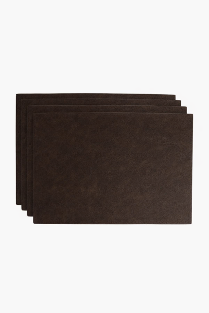 Stack of dark brown leather card sleeves on a light background