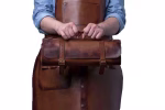 Knife holder professional 11s fully open held up by chef, showing all 9 knives, scissors and sharpening rod in leather slots