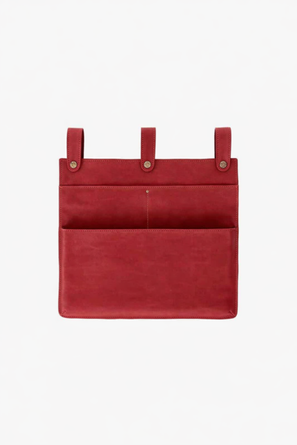 Red leather wall pocket organizer with three hanging tabs on a light background.