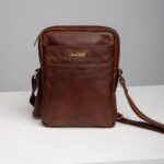 Mens brown leather reporter crossbody bag front view with front pocket