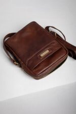 Top angle of the brown leather reporter bag with adjustable shoulder strap