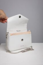 White leather envelope bag opened showing zip pocket and snap button
